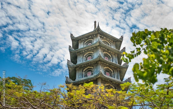 Obraz Ancient Buddhist pagoda against the blue sky and clouds. Vietnam.