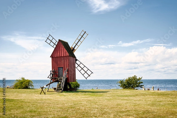 Fototapeta Windmill on the shore edge facing Kalmarsund on the Swedish island Oland.