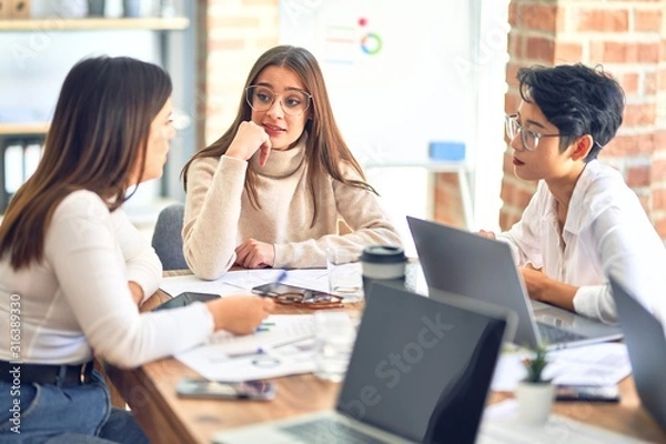 Fototapeta Beautiful businesswomen smiling happy. Sitting with smile on face working using laptop at the office