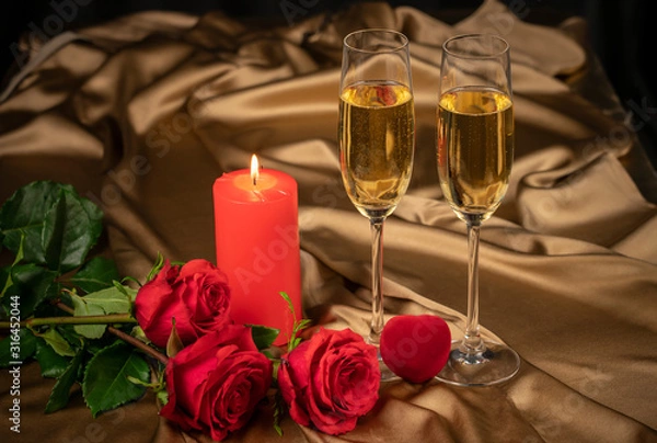 Fototapeta Valentine's day card, two glasses of champagne on a gold background red roses and a red heart, a lighted candle