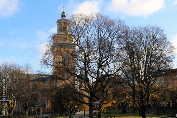 Fototapeta Church in Stockholm in Sweden Europe. With a blue sky on a autumn day. With trees in the front