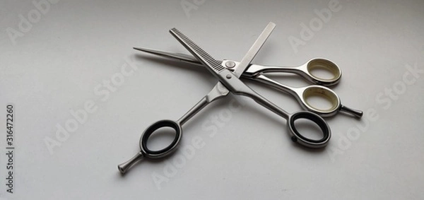 Fototapeta Hairdressing scissors lie on top of each other, one open, side view