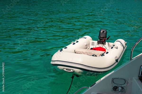 Obraz rubber  dinghy  on the emerald green sea