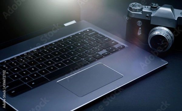 Fototapeta Laptop computer and film camera on the table 