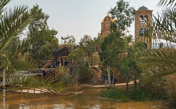 Fototapeta a group of pilgrim tourists gather at the site of the baptism of jesus on the recently flooded jordan river