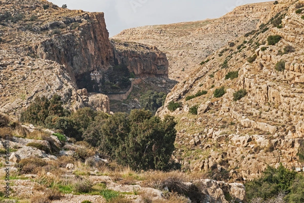 Fototapeta an ancient byzantine monastery clings to the side of a cliff in the ein prat reserve in wadi qelt in the west bank of israel and palestine