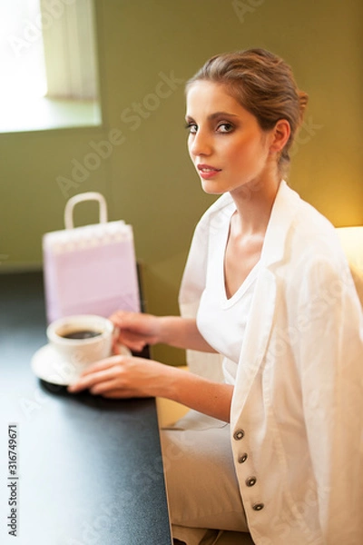 Fototapeta Portrait of Sophisticated woman sitting and drinking coffee