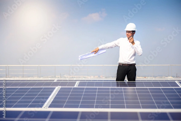 Fototapeta Solar power plant. Engineer & Manager with radio communication  on photovoltaic panels, on building roof ,  Renewable energy Concept