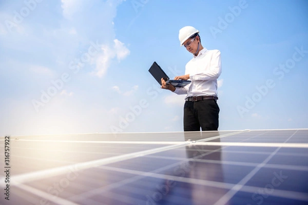 Fototapeta Solar power plant. Engineer & Manager with tablet computer on photovoltaic panels, on building roof ,  Renewable energy Concept
