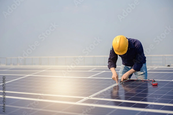 Fototapeta Electrician working on measurement Voltage at solar cell on building roof ,  Renewable energy Concept.
