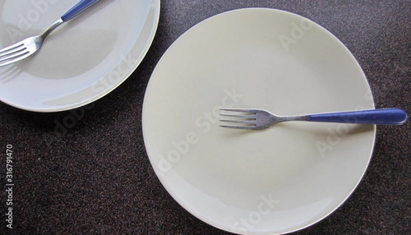 Fototapeta Creamy smooth plates with forks on top of a dark background