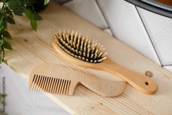 Fototapeta Spa and bath cosmetics, basket with towel rolls in rustic interior. Natural materials in bathroom. Wooden hair brush. Bamboo comb on the dressing table. Eco-friendly hair care products. Natural beauty