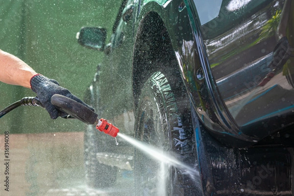 Obraz People cleaning car with high pressure water