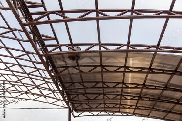 Obraz A worker mounts a metal canopy