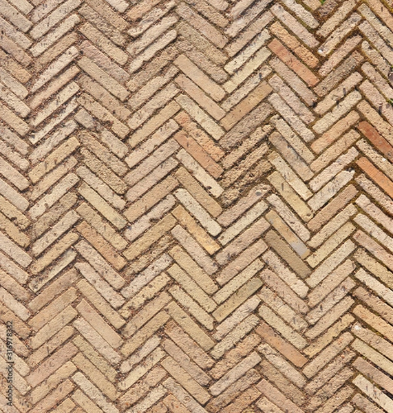 Fototapeta Pattern with modern rectangular herringbone yellow tiles. Diagonal texture. Abstract backdrop of old  brick ceramic cobblestone pavement close-up.