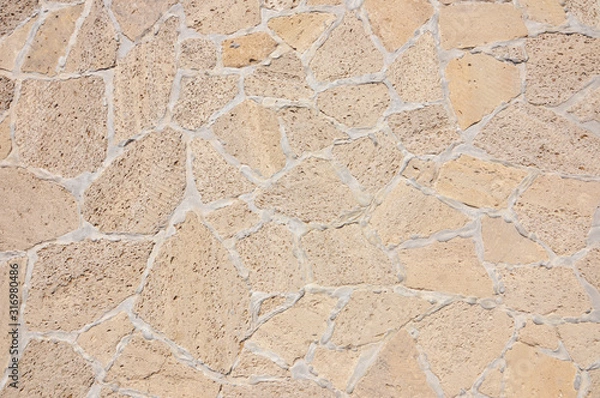 Fototapeta Old beige stone wall background texture close up. Old castle stone wall texture