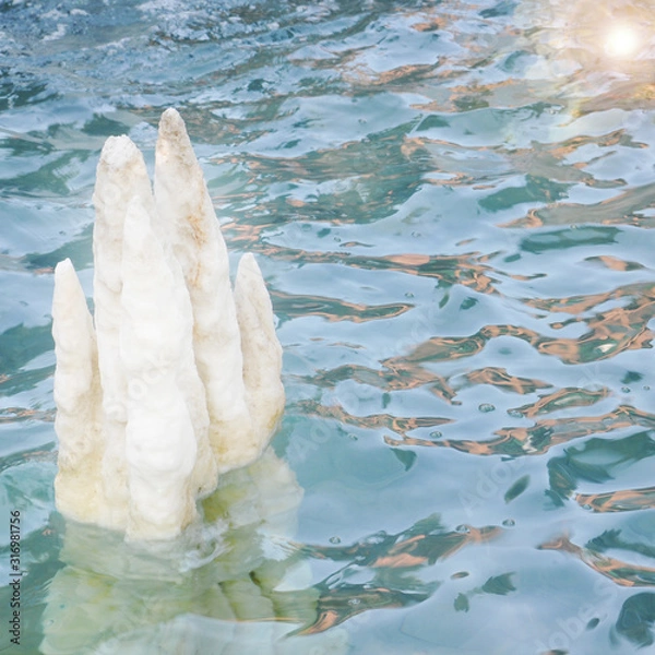 Fototapeta Salt crystals protruding from the water surface of turquoise color in the lake. Picture for relaxation with rippling water and crystal