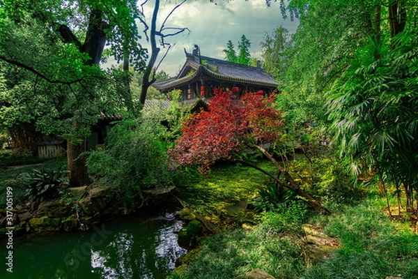 Obraz Small temple hidden in the middle of the vegetation. The green of the leaves contrasts with the red of the tree. Wuhou Temple, Chengdu city, China