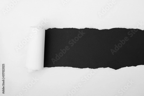 Obraz torn white paper frame on black backdrop
