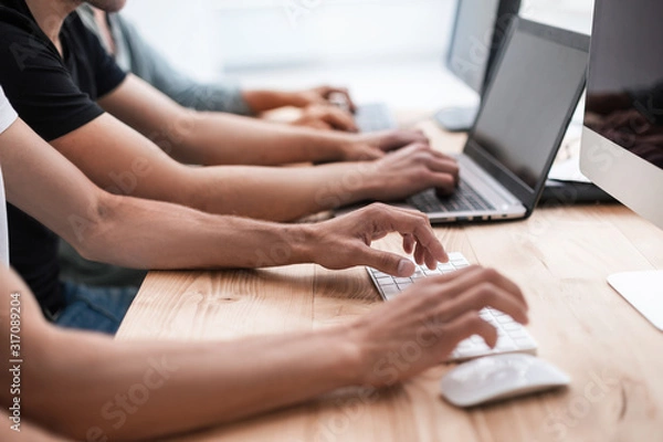 Fototapeta close up. a group of employees work on their computers