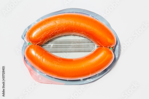 Fototapeta Use less plastic! pork sausage in plastic packaging isolated on white ground. Symbol for environmental pollution done by the food industry