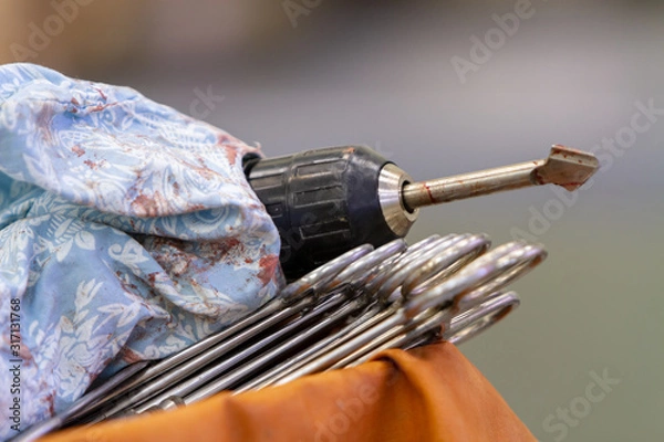 Fototapeta close-up of a drill with a drill after use for craniotomy lies on a table next to the clamps