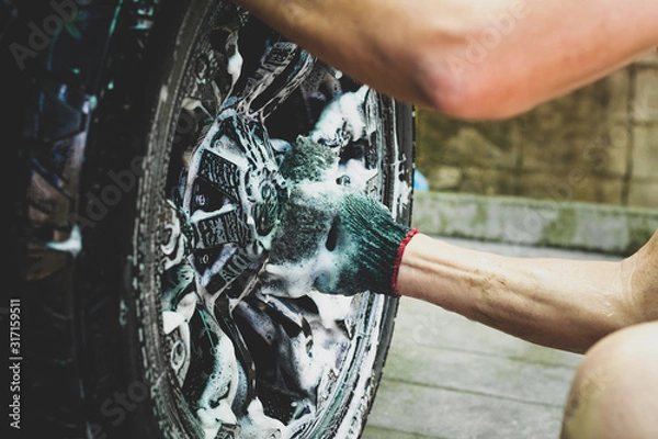 Obraz People cleaning car with sponge at automobile wheels wash