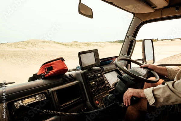 Obraz A man driving a tour truck on sand dunes in Australia