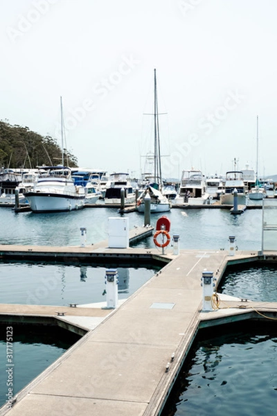 Fototapeta Luxury yachts and fishing boats parked with a concrete walkway at pier of Nelson Bay