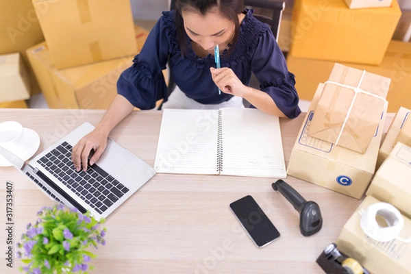 Obraz Top view, Asian women who are SME online shopping operators and are writing lists on notebooks SME online shopping business entrepreneurs or independent work concept