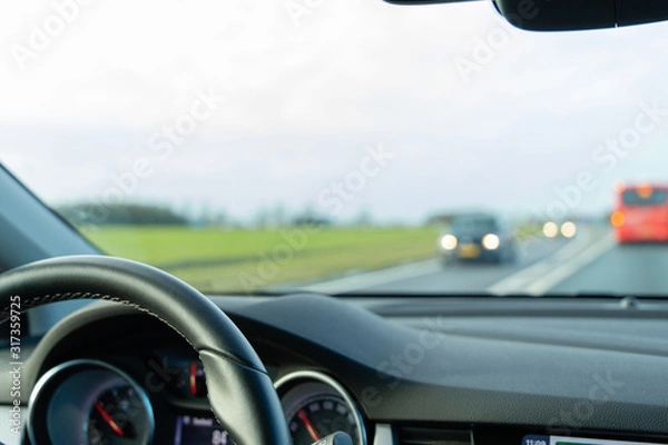 Fototapeta Car dashboard while driving on the highway in the dutch landscape