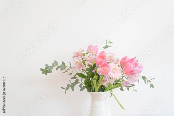 Fototapeta 白い花瓶とピンク系の花　おしゃれ　アレンジ　春　季節　部屋　白い壁　白背景　テーブル　フラワーアレンジメント　インテリア写真　春の花　花器　家　白バック　花瓶　　縦