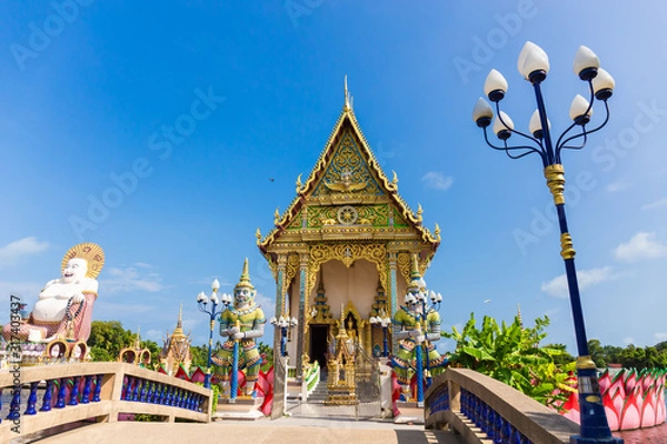 Fototapeta The Thai temple in Wat Plai Laem in Samui Island Thailand, in the middle of the water, contains giant statues and elephants.Pigeon flies through.