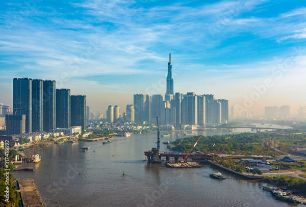 Fototapeta Saigon, Vietnam - CIRCA Jan 2020: Long exposure Saigon aerial cityscape, showing Landmark 81 Building in the background, MRT lin construction in the right, and Saigon River.
