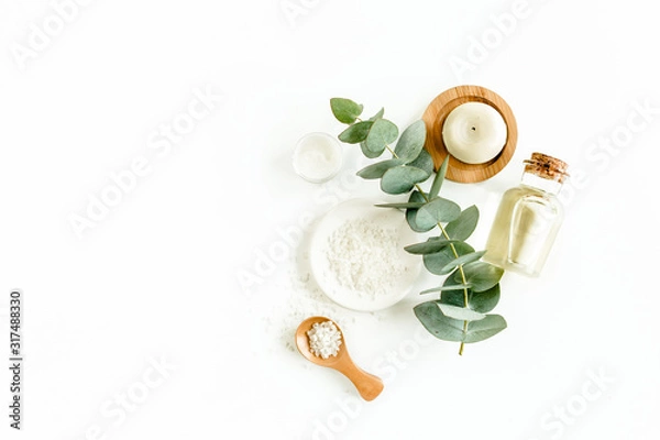 Fototapeta Bottle of eucalyptus essential oil, eucalyptus leaves on white background. Natural / Organic cosmetics products. Flat lay, top view.
