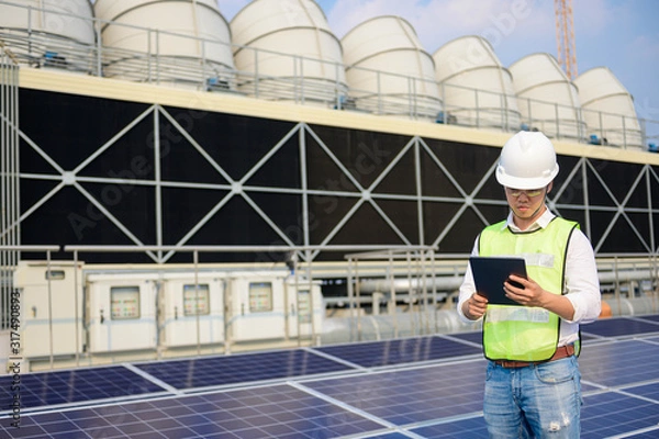 Obraz Engineer check condition  Solar cell roof top and cooling tower project at industry solar power, Renewable energy Concept.