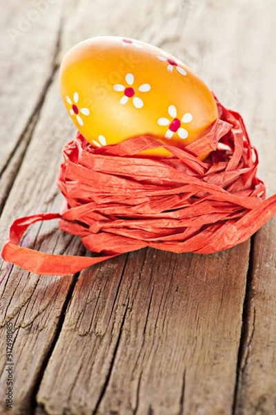 Fototapeta Easter background. Macro shot of painted egg and ribbon decoration on old wooden texture