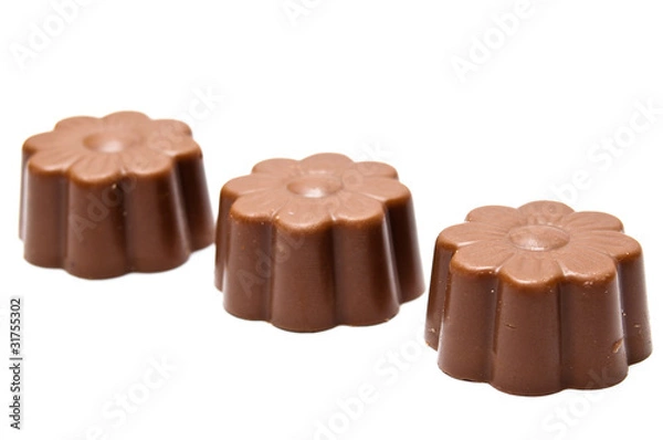 Obraz Three daisy shaped chocholate assortments in diagonal arrangemen