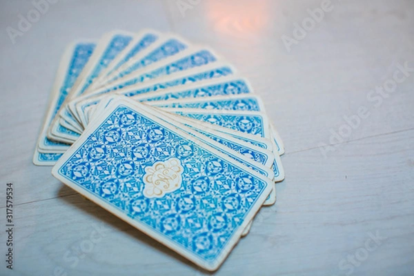 Obraz Tarot cards in fortune teller hand on white wooden table background. Future reading.