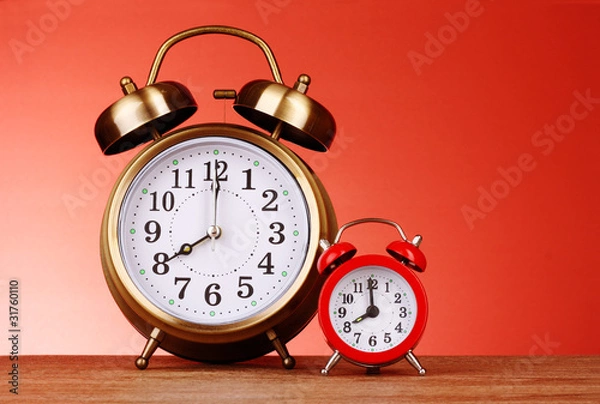 Fototapeta Two Alarm-clocks on red background