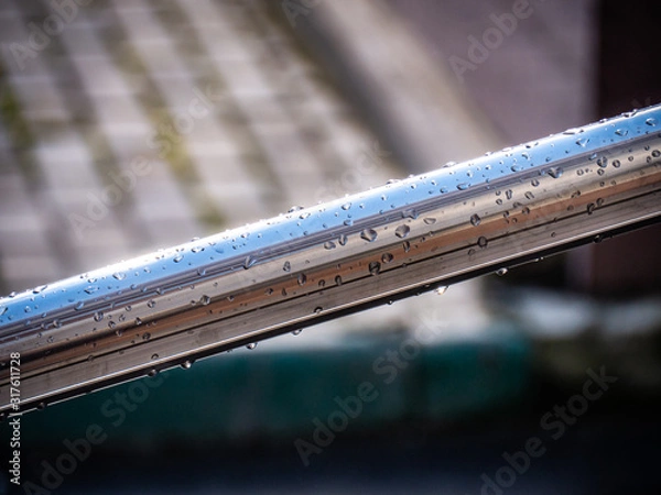 Fototapeta Raindrops on a shiny metallic handrail