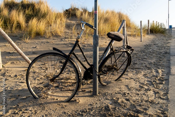 Fototapeta Bicycle left behind on the beach in Holland in the dunes