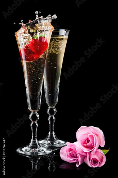 Fototapeta Two glasses of sparkling splashing wine (champagne) with pink roses and strawberry on black