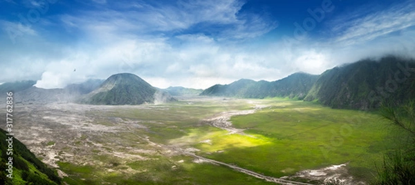 Obraz Clouds of thick white smoke emitted by erupting volcano and drifting over ground. Mount Bromo eruption. Tengger Semeru National Park amazing landscape. East Java, Indonesia. Bird's eye view