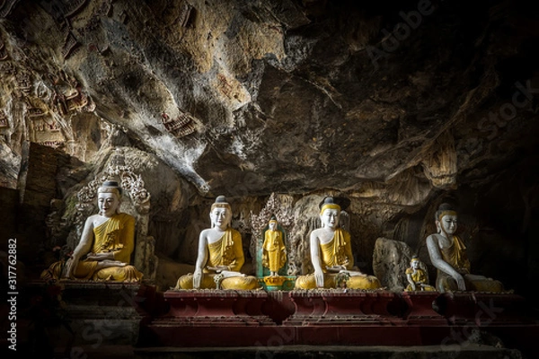 Fototapeta Buddhas statues and religious carving in Kaw Goon cave. Hpa-An, Myanmar