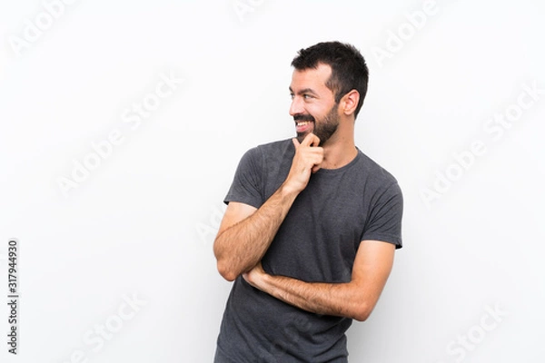 Fototapeta Young handsome man over isolated white background looking to the side