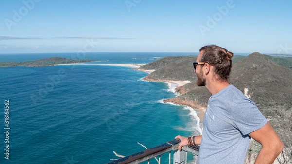 Fototapeta Man standing on the edge of a cliff viewpoint