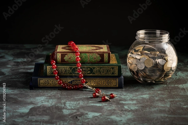 Obraz Zakat concept: Quran and tasbih with jar full of coins