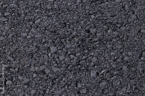 Fototapeta Dark black background from adjoined rolled asphalt. Modern technologies of solid pavement for vehicles and pedestrians. Elements of the construction of highways. The granular structure of small stones