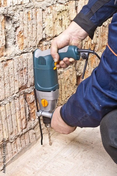 Obraz House-builder working with a perforator
